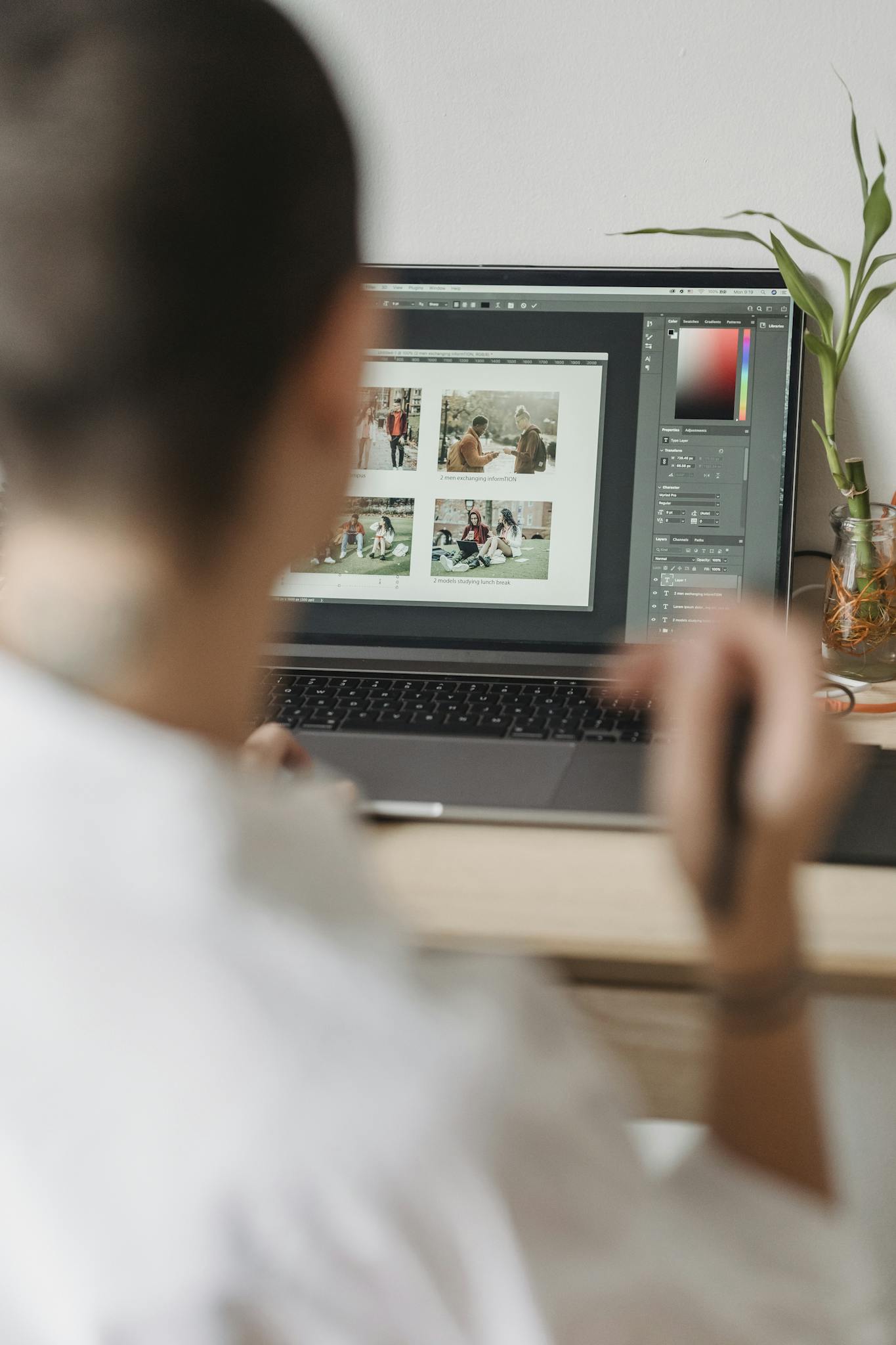 Freelance photographer retouching images on a laptop in a modern indoor workspace.